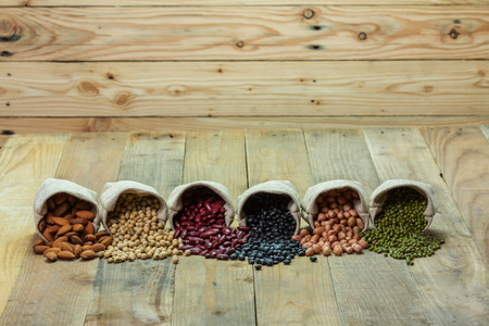 Different kinds of beans scattered on wooden backgroundの写真素材