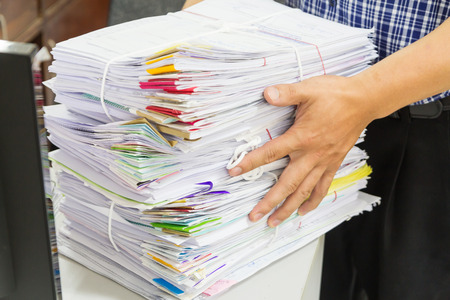 Hand holding stack of papework