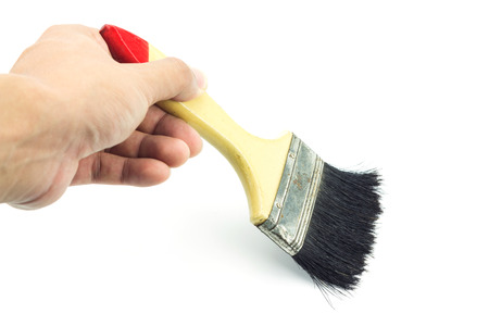 Hand holding paint brush on white backgroundの写真素材