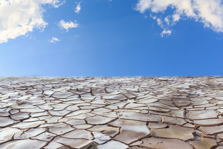 Cracked land with blue sky and cloudsの写真素材