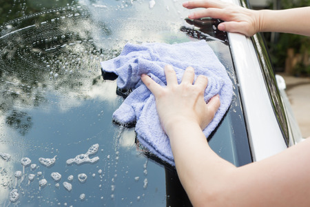 Woman hands washing a white carの写真素材
