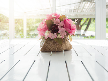 Bouquet of beautiful artificial flowers on white wooden table in a coffee shopの写真素材