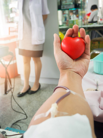 Nurse receiving blood from blood donor in hospital.の写真素材