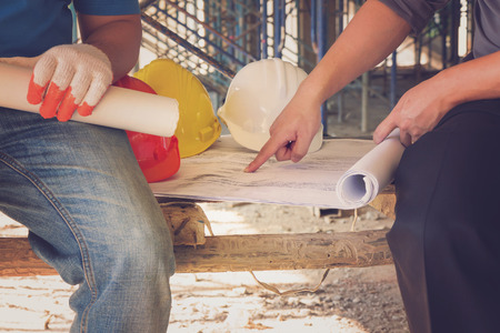 Construction concepts, Engineer and Architect working at Construction Site with blueprint, Vintage...
