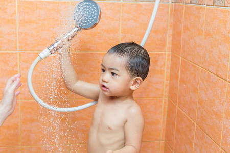 Child bathing with mother in bathroomの写真素材
