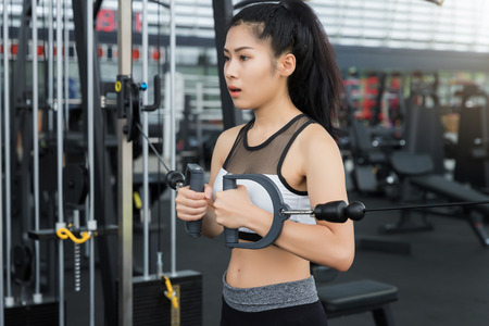 Closeup of a young fitness asian woman workout at sport club.