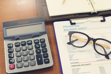 Business and finance concept of analysis chart, eyeglasses and calculator on office desk