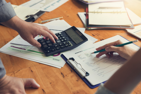 Business and finance concept of office working,Teamwork of Businessmen using calculator to discussing analysis Chartの写真素材