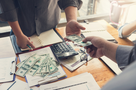 Business and finance concept, Hand of a businessman giving money to his partnerの写真素材