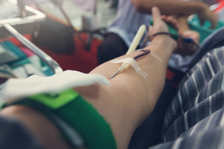 Nurse receiving blood from blood donor in hospital.の写真素材
