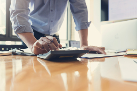 Business and finance concept of office working, Businessman using calculator to discussing sale analysis Chartの写真素材