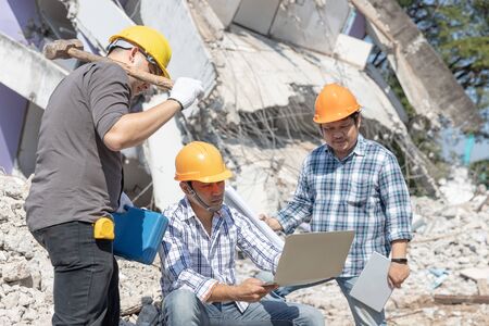 Engineer architect and worker operation control demolish old building.