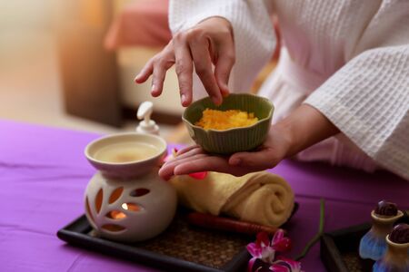 Asian woman holding salt scrub for massage at spa.の写真素材