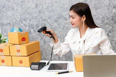 Young teenage prepare to send goods to customer after checking order, work at home.の写真素材