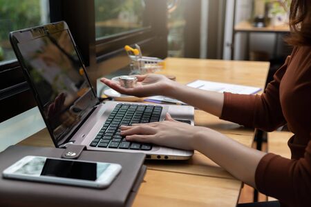 Freelancer business woman holding credit cart to shopping online with computer laptop in cafe.の写真素材
