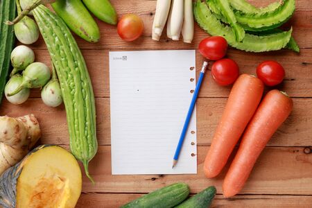 Thai kitchen. Various vegetables, spices  and Ingredients with blank note page and pencil on wooden background. Top view with copy spaceの写真素材