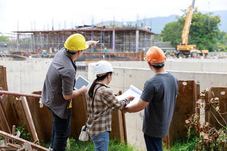Construction concept of Engineer and Architect working at Construction Site with blue print