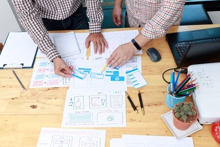 Graphic designers work together with UX UI designer planning application template layout framework...