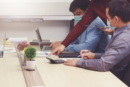 New normal and Social distance conceptual, Employee wearing medical facial mask working in office.の写真素材