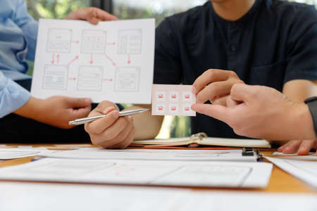 Graphic designers work together with UX UI designer planning application template layout framework...