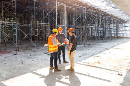 Construction concept of Engineer and Architect working at Construction Site with blue print