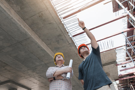 Construction concept of Engineer and Architect working at Construction Site with blue print
