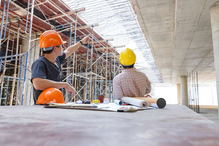 Construction concept of Engineer and Architect working at Construction Site with blue print