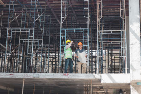 Construction concept of Engineer and Architect working at Construction Site with blue print