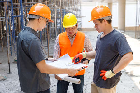 Construction concept of Engineer and Architect working at Construction Site with blue print
