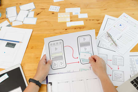 Graphic designers work together with UX UI designer planning application template layout framework...