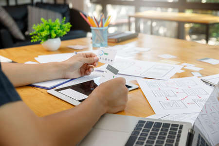 Graphic designers work together with UX UI designer planning application template layout framework...