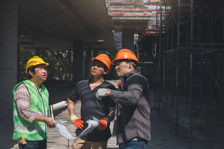Construction concept of Engineer and Architect working at Construction Site with blue print