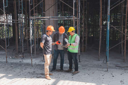 Construction concept of Engineer and Architect working at Construction Site with blue print