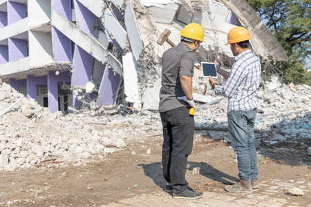 Engineer architect and worker operation control demolish old building.の写真素材