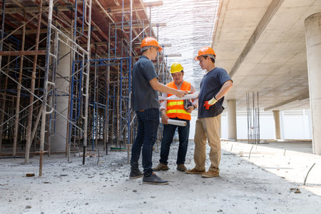 Concept of construction. Engineer, architect and designer working together at the construction site, Foreman or engineer checking the accuracy of the construction work by using blueprints..の写真素材