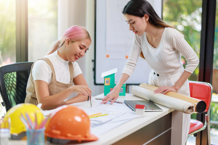Construction and architect home building company concept, Engineers, architects and designers work together to design home or resident housing and validate blueprints in the workplace.の写真素材