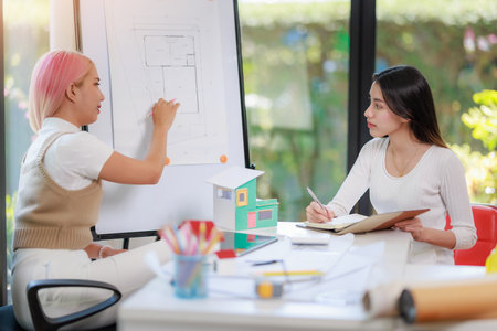Construction and architect home building company concept, Engineers, architects and designers work together to design home or resident housing and validate blueprints in the workplace.の写真素材
