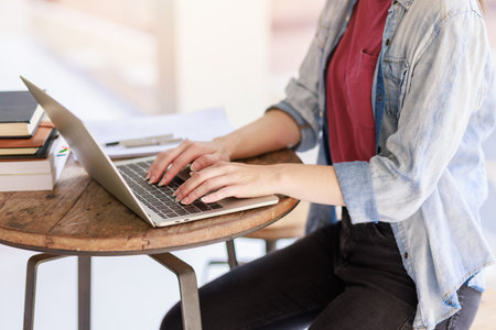 Education concepts, High school Young female student or college students studying reading or researching and doing homework using computer laptop or tablet calculator for learning onlineの写真素材
