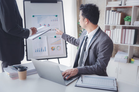 Finance and investment concept, Businessman present business finance investment plan with his partner, Investor colleagues discussing new investment plan by financial graph data on office tableの写真素材