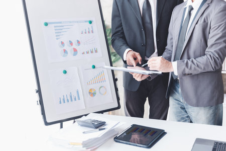 Finance and investment concept, Businessman present business finance investment plan with his partner, Investor colleagues discussing new investment plan by financial graph data on office tableの写真素材