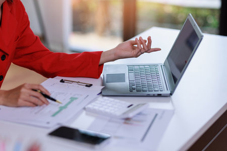 Concept of business invesment or woman working,Closeup businesswoman checking her invesment plan with analyzing document and business investment graph data by using calculator and computer laptopの写真素材