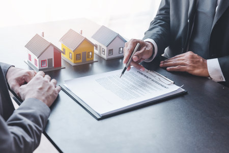 Home sales,home rental and real estate concept.Customer sign the document after real estate agent explain about the terms of the home purchase or rental agreementの写真素材