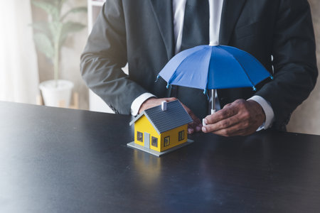 Concept of home insurance, Insurance officer agen use umbrella protecting the houseの写真素材