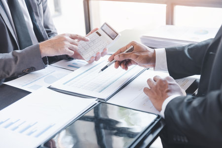 Finance and investment concept, Businessman present business finance investment plan with his partner, Investor colleagues discussing new investment plan by financial graph data on office tableの写真素材