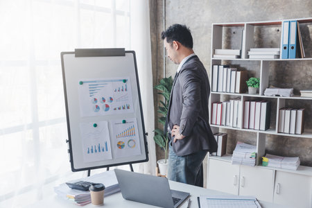 Finance and investment concept, Businessman present business finance investment plan with his partner, Investor colleagues discussing new investment plan by financial graph data on office tableの写真素材