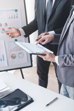 Finance and investment concept, Businessman present business finance investment plan with his partner, Investor colleagues discussing new investment plan by financial graph data on office tableの写真素材