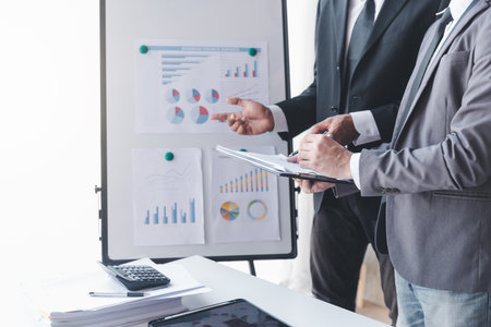 Finance and investment concept, Businessman present business finance investment plan with his partner, Investor colleagues discussing new investment plan by financial graph data on office tableの写真素材