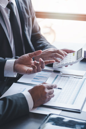 Finance and investment concept, Businessman present business finance investment plan with his partner, Investor colleagues discussing new investment plan by financial graph data on office tableの写真素材