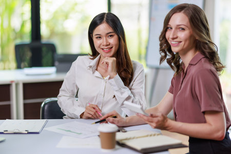 Concept of business office woman working,à¸º Businesswoman working with investment plan with her partner and analyzing document business investment graph data by using calculator and laptopの写真素材