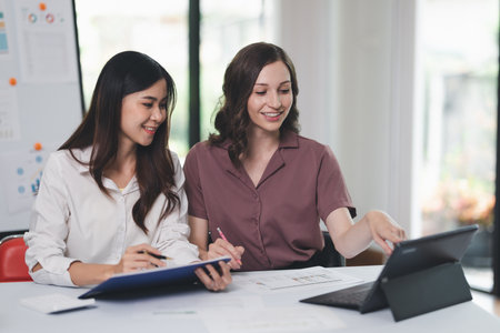 Concept of business office woman working,à¸º Businesswoman working with investment plan with her partner and analyzing document business investment graph data by using calculator and laptopの写真素材